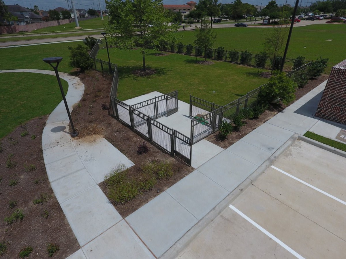 A neatly landscaped outdoor area with pathways and fenced enclosures.
