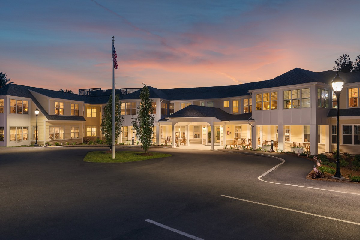A modern building with a flagpole at sunset.