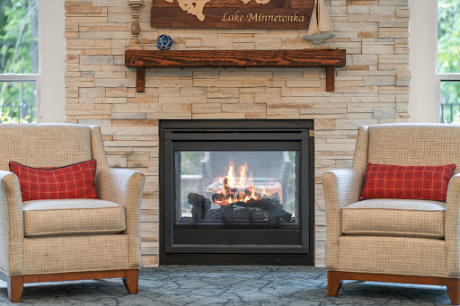 A cozy living room featuring a modern fireplace and comfortable armchairs, perfect for relaxation.