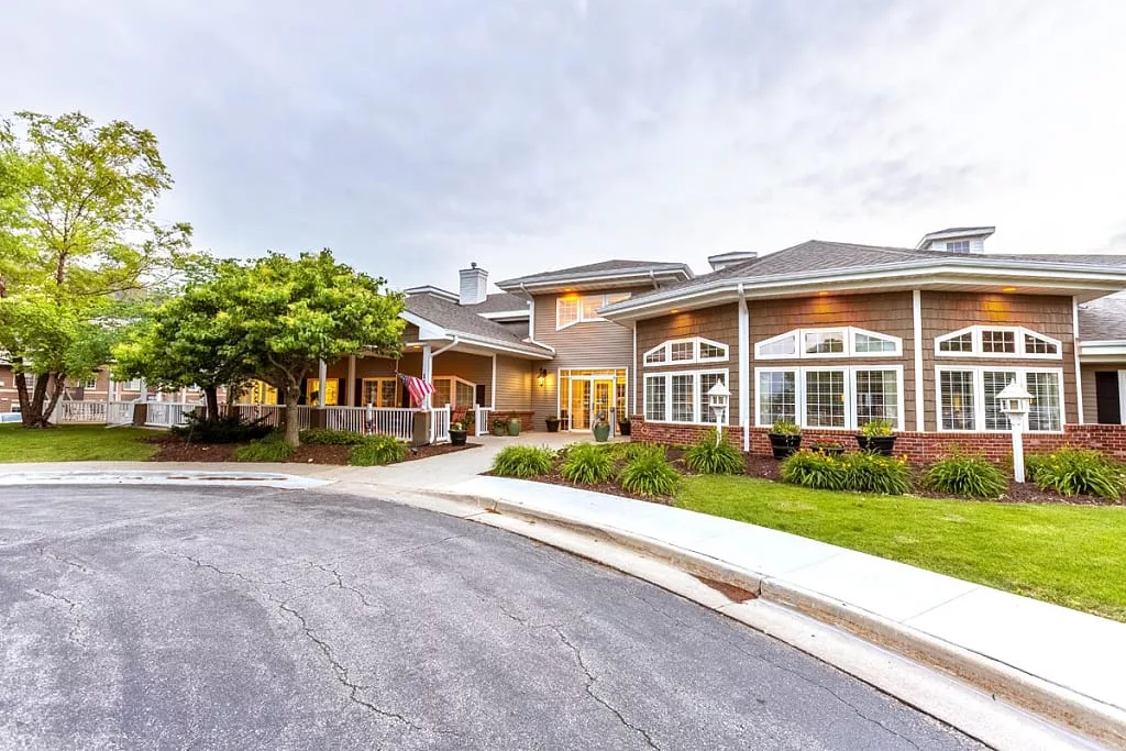 A well-maintained residential building with a landscaped driveway and trees.