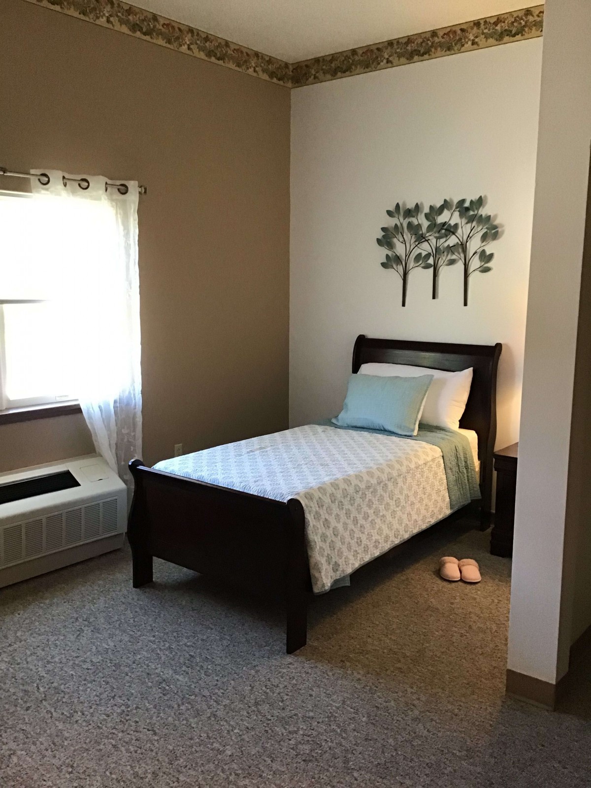 A minimalist bedroom with a single bed and soft natural lighting.