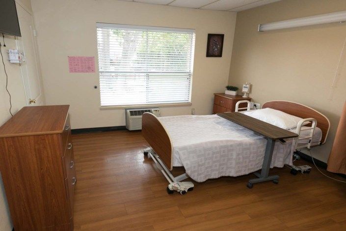 A clean and minimalist hospital room with a patient bed and window.