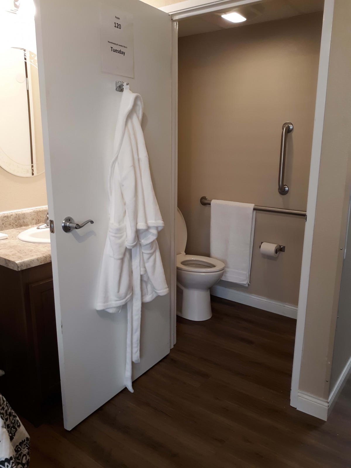 Modern bathroom with robe and towel hanging.