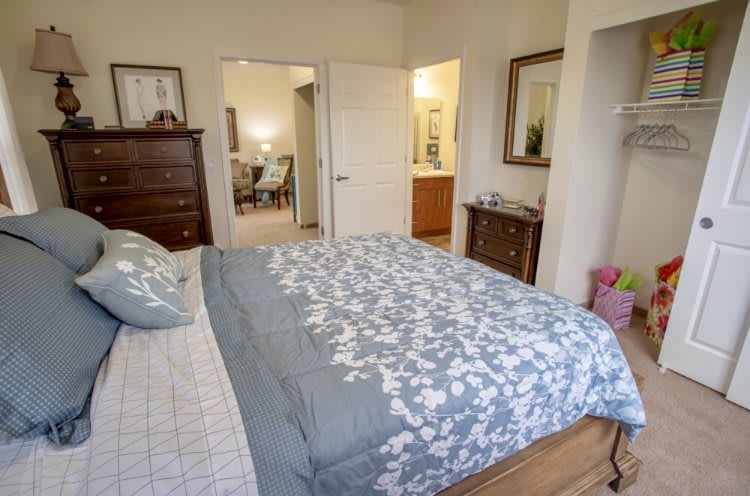 A cozy bedroom with a neatly made bed and elegant furniture.