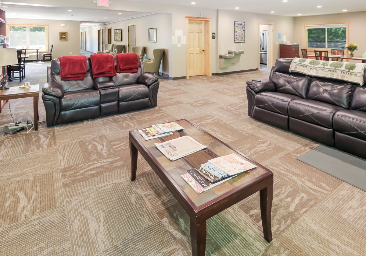 A cozy waiting room with comfortable couches and a coffee table stocked with magazines.