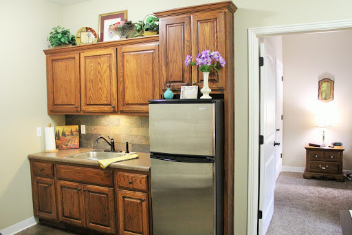 A cozy kitchen featuring wooden cabinets, a stainless steel refrigerator, and a well-organized countertop.