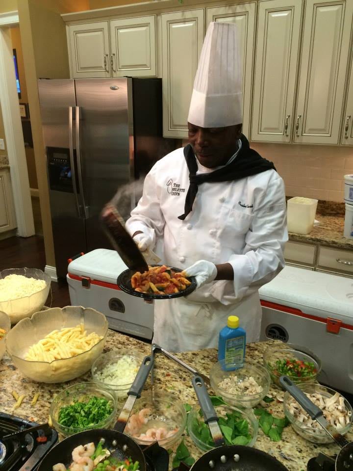 A chef in a professional kitchen preparing a dish with precision.