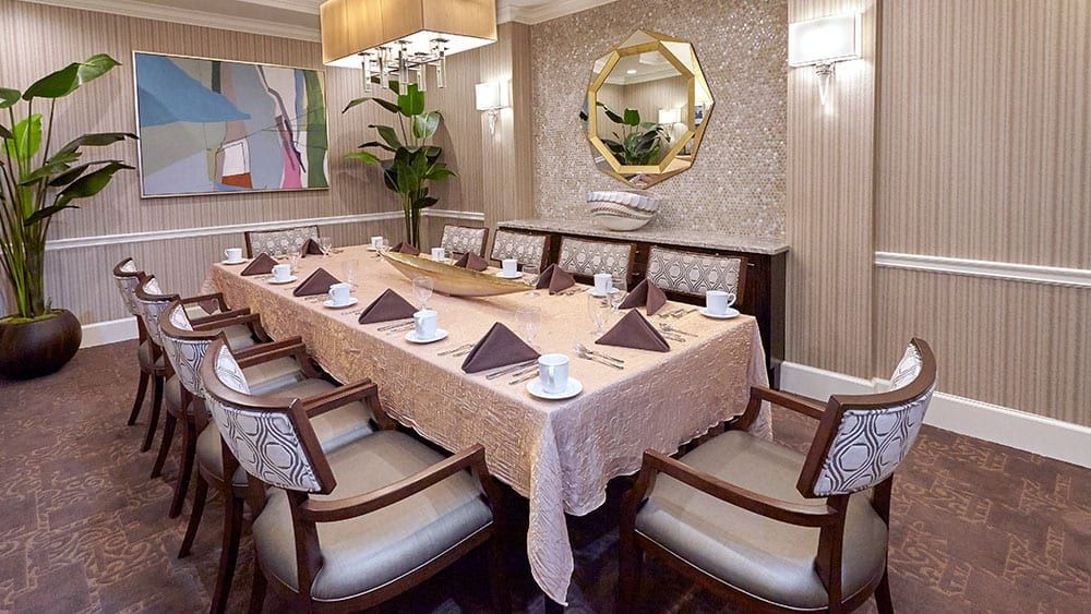A luxurious dining room with an elegantly set table, complete with napkins and fine decor.