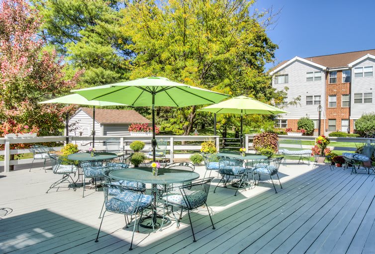 Outdoor patio area with tables, chairs, and umbrellas on a sunny day.