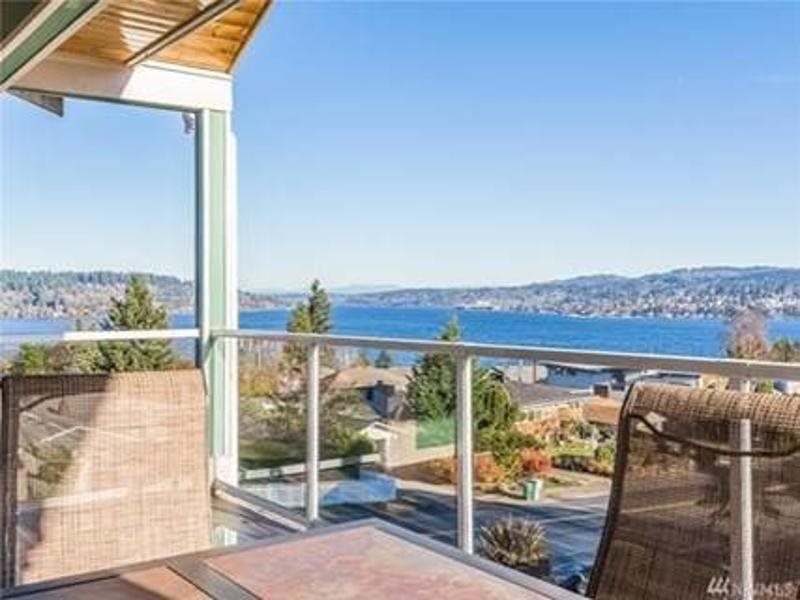 A scenic balcony view overlooking a lake and mountains.