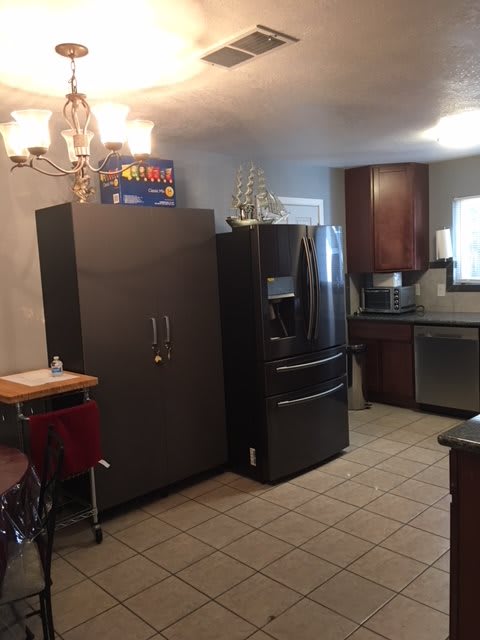 A modern kitchen with two large refrigerators and dark wood cabinets.