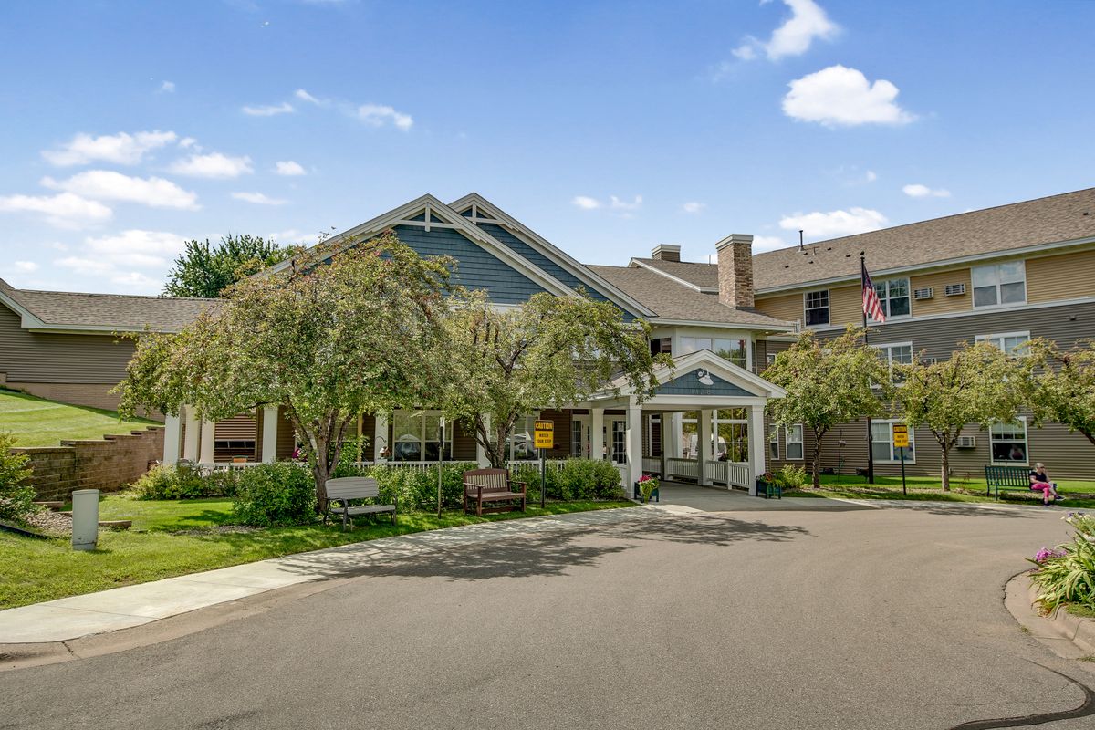 A picturesque building with an inviting entrance surrounded by trees and a clear sky.