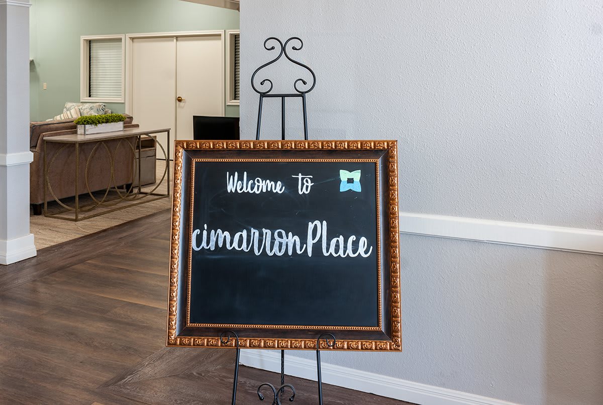A welcoming chalkboard sign at the entrance of Cimarron Place.