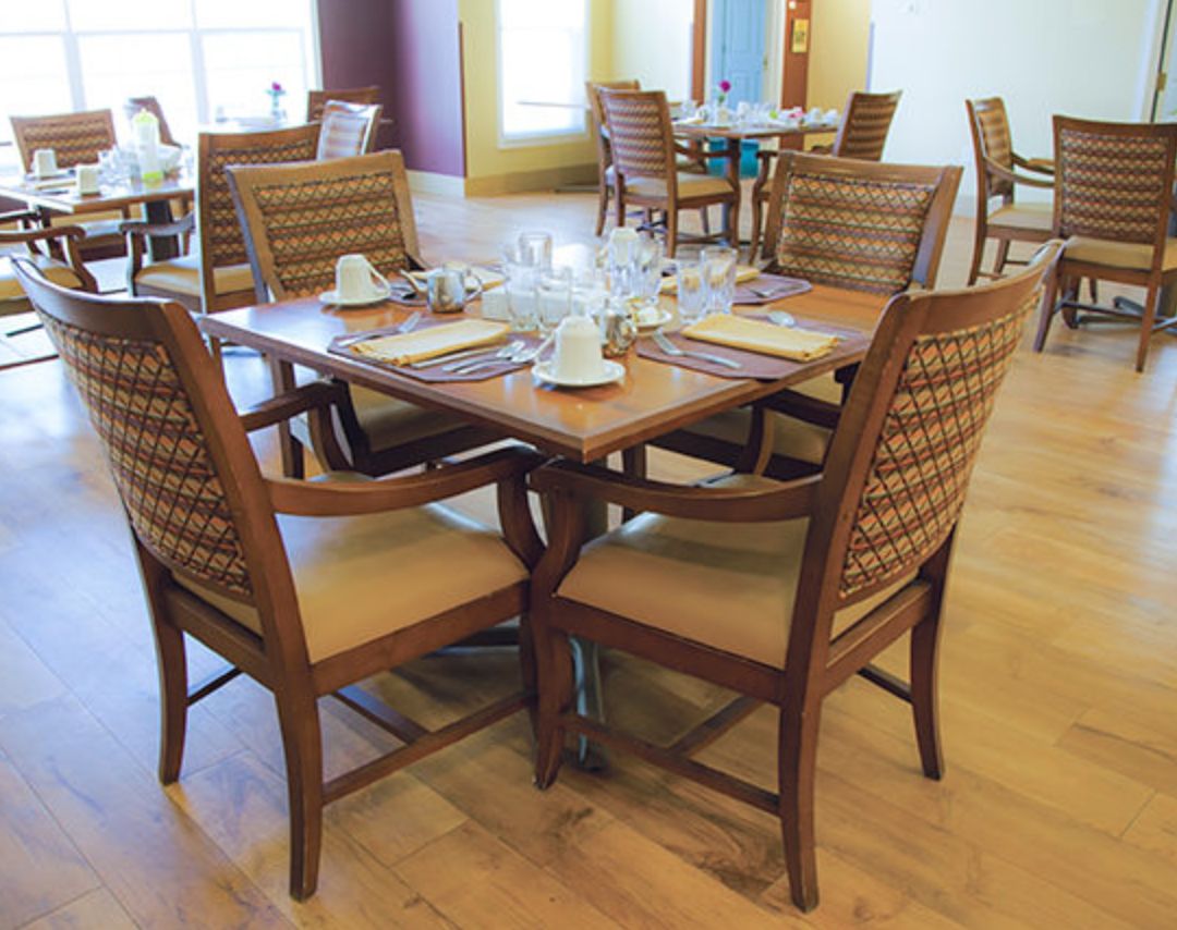 A restaurant dining area with a neatly set table including glasses and cups.