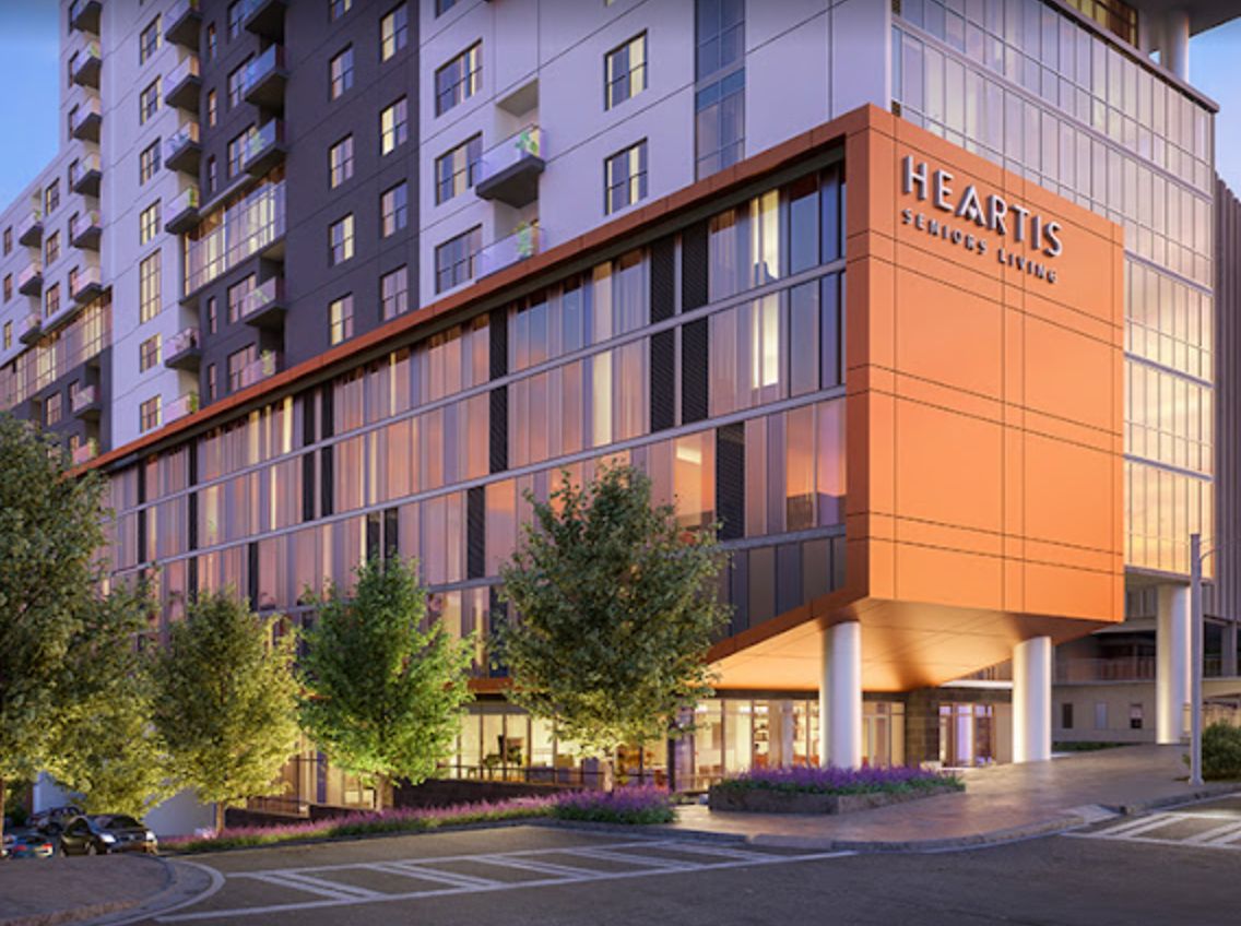 A modern urban building with sleek architecture and surrounding trees.