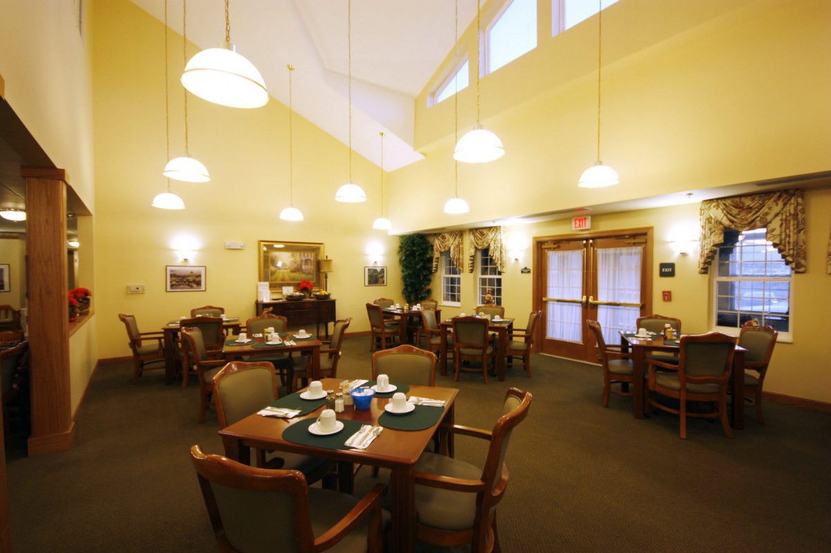 A cozy dining area with neatly set tables and warm lighting.
