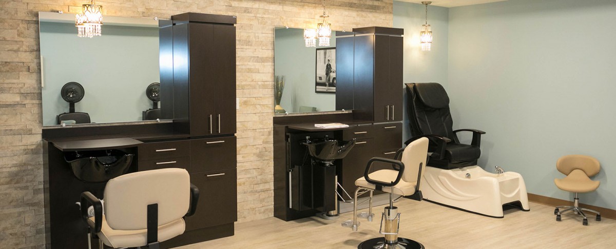 A modern hair salon interior with chairs, mirrors, and stylish lighting.