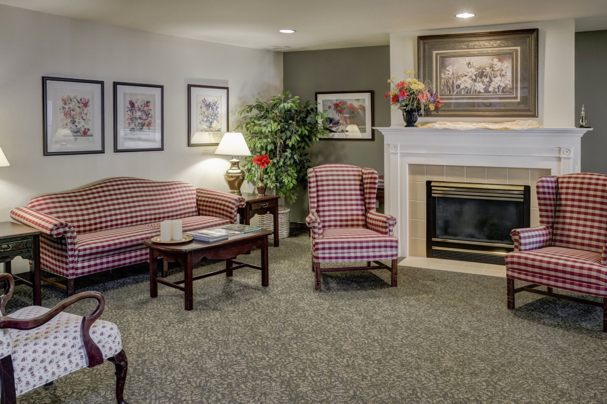 A cozy living room with patterned furniture, a fireplace, and decorative elements.