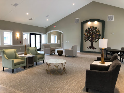 A modern lounge area featuring comfortable seating and a decorative tree art piece.