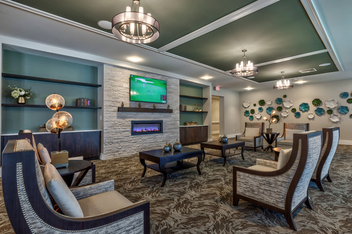 A modern living room with stylish furniture, a fireplace, and a mounted television.