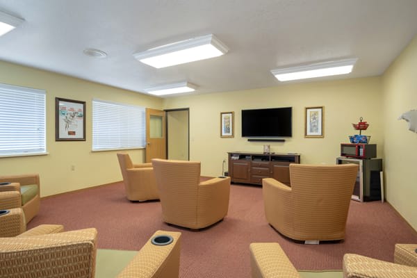 A modern waiting room with comfortable seating and a television.