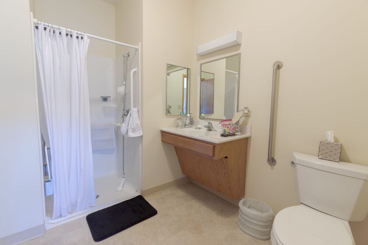 A clean and minimalist bathroom with a shower, sink, and toilet.