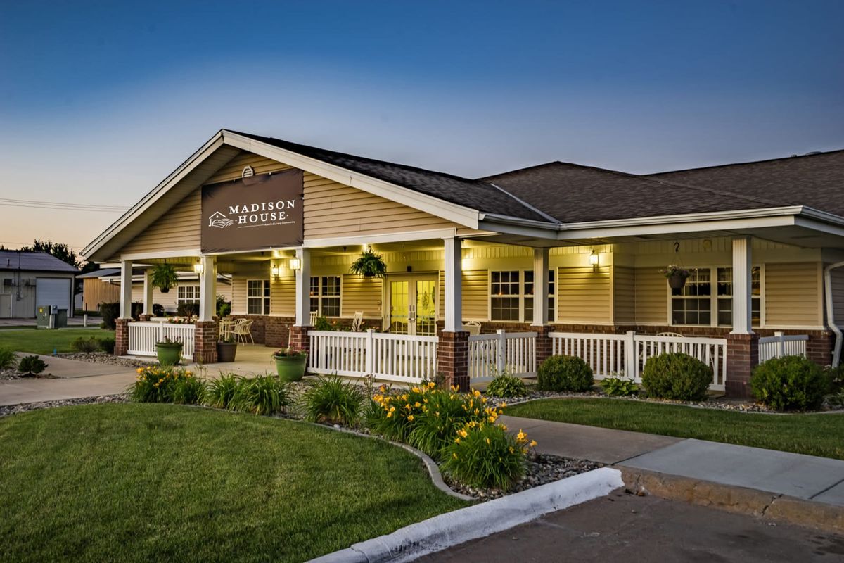 A cozy restaurant building with a welcoming porch, set against the evening sky.