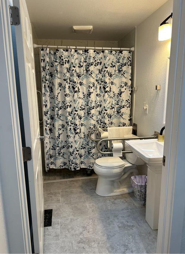 A clean and organized bathroom with a patterned shower curtain.