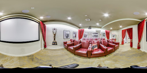 A cozy home theater featuring red leather chairs and framed photographs, perfect for movie nights.