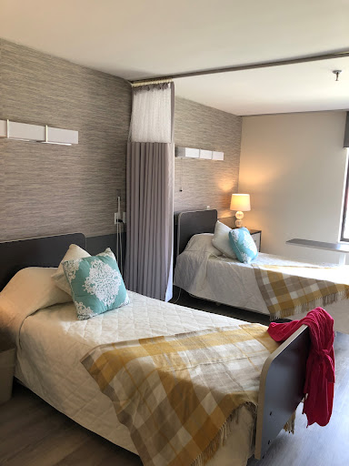 A modern bedroom featuring two neatly made beds, soft lighting, and a cozy decor.