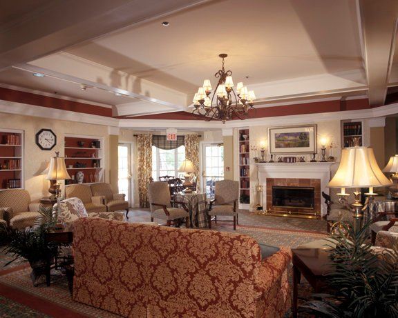 A traditionally styled living room featuring elegant furniture, a chandelier, and a fireplace.