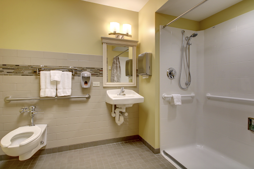 A well-equipped bathroom featuring a shower, sink, and essential amenities.
