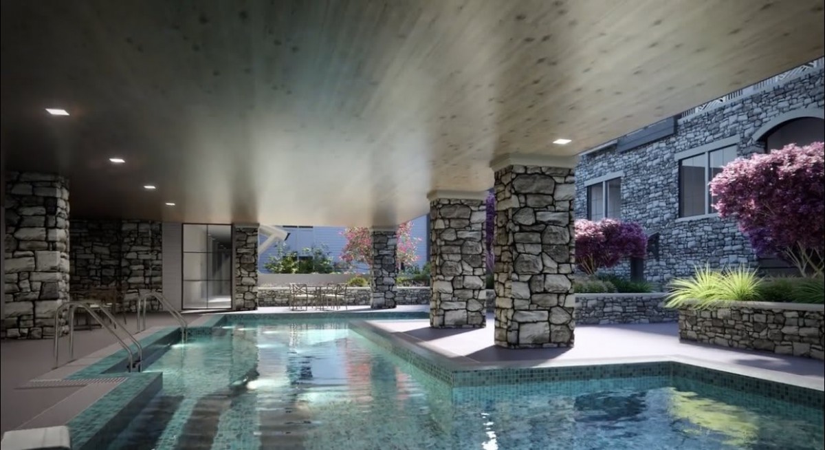A luxurious indoor pool area with modern architecture and stone pillars.