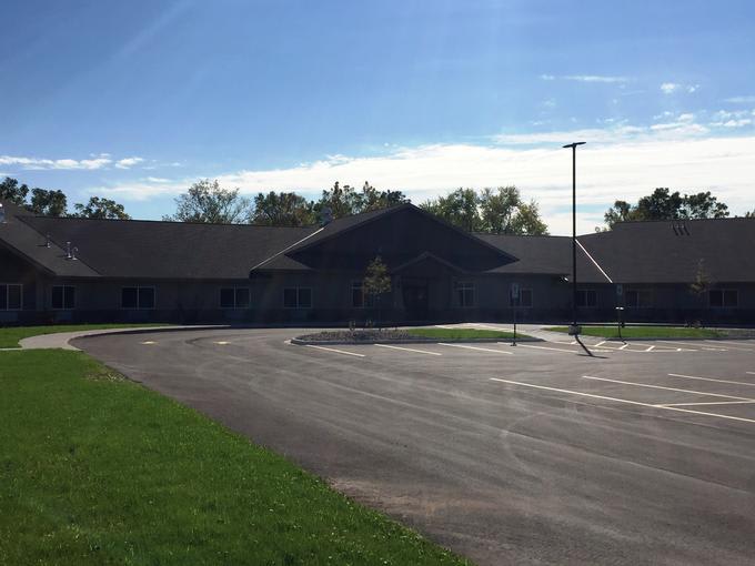 A suburban building with a parking lot on a sunny day.