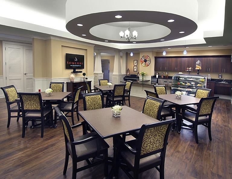 A modern cafe interior with neatly arranged tables and chairs, featuring elegant lighting and decor.