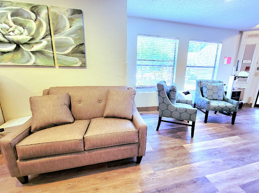 A cozy living room setup featuring a comfortable sofa and stylish chairs, illuminated by natural light.