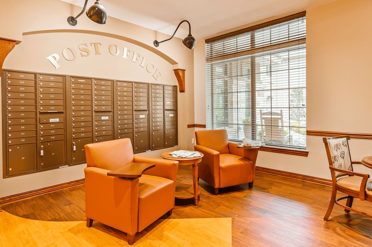 A cozy post office interior with mailboxes and a comfortable seating area.
