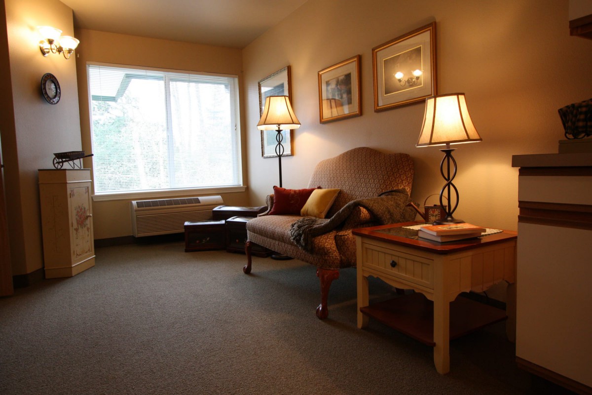 A cozy living room with a sofa, table lamps, and artwork on the walls.
