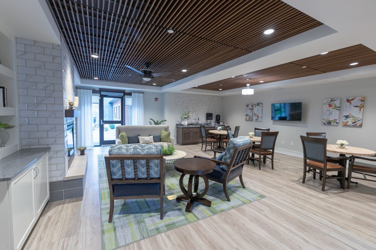 A modern, stylish living room with comfortable seating and a wooden ceiling.