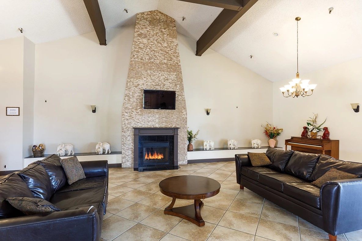 A cozy living room with a stone fireplace and modern furnishings.