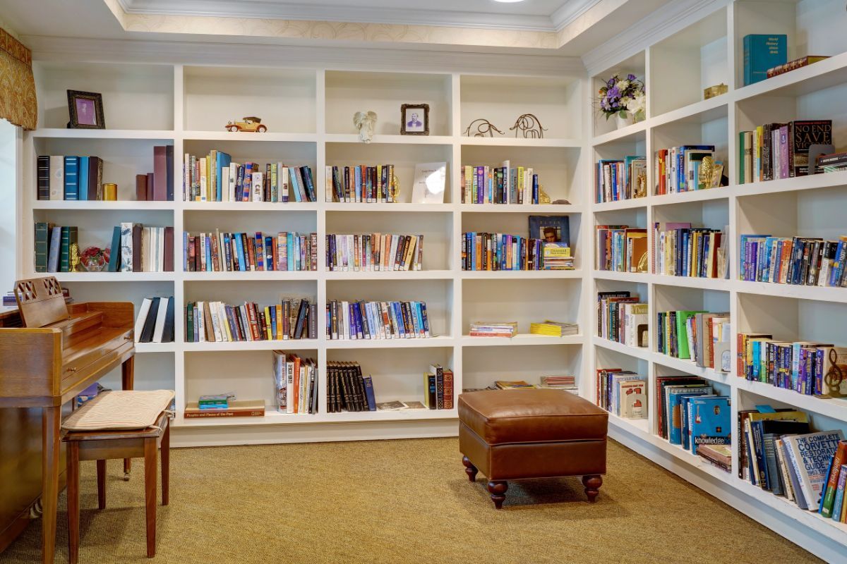 A cozy reading area with white bookshelves filled with books and a comfortable seating arrangement.