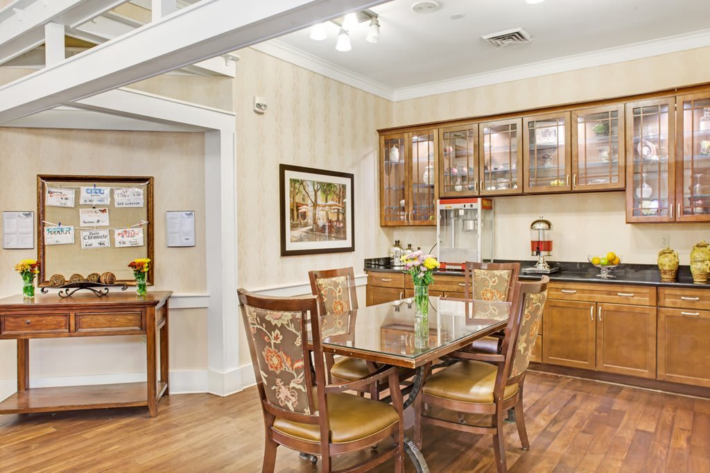 A cozy dining area with wooden furniture and a well-equipped kitchen in the background.