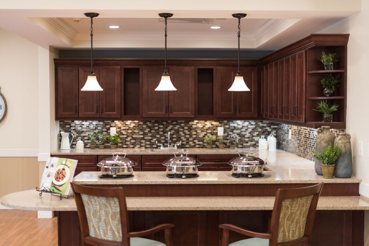 A beautifully designed kitchen featuring a bar counter with pendant lighting and rich wood cabinetry.