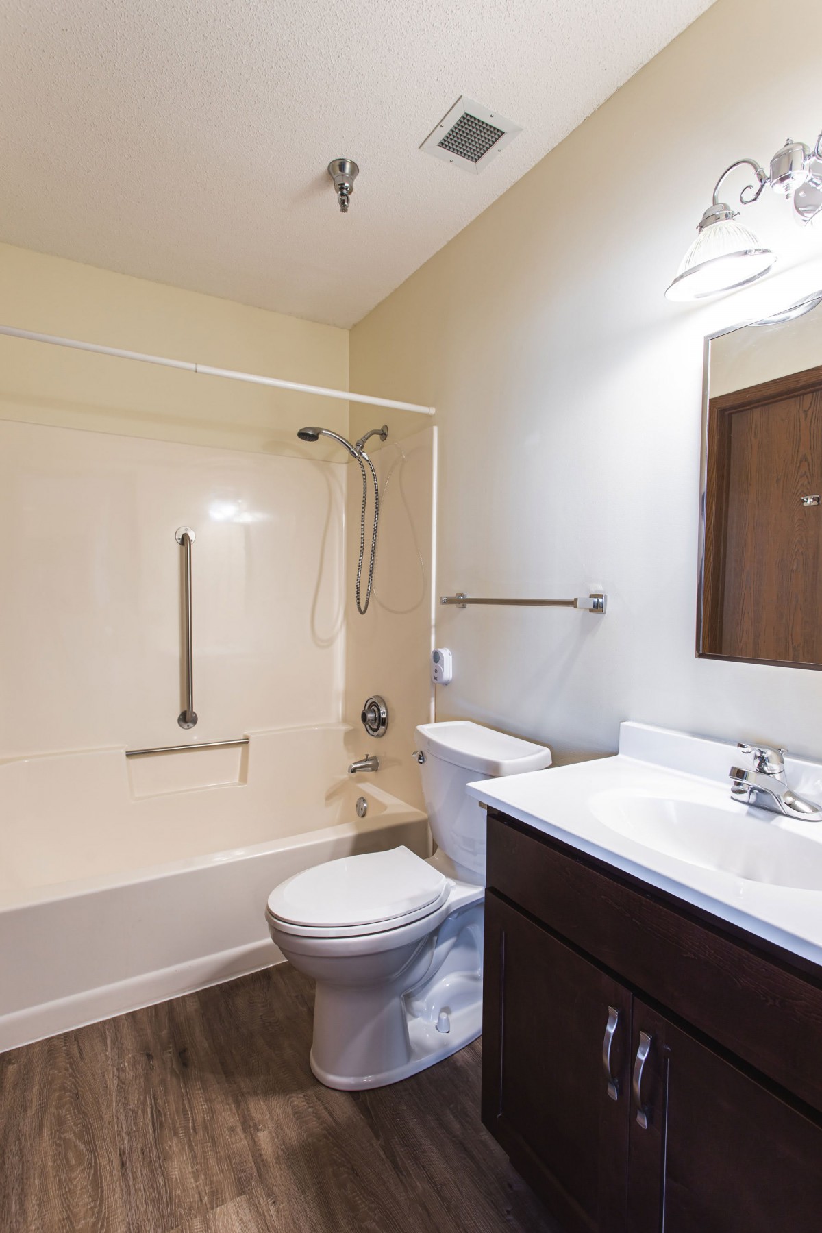A clean and simple bathroom with a bathtub, shower, toilet, and sink.