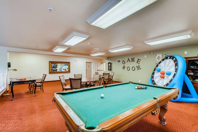 A recreational game room featuring a pool table and card tables.