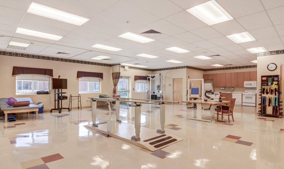 A spacious physical therapy room with exercise equipment and rehabilitation tools.
