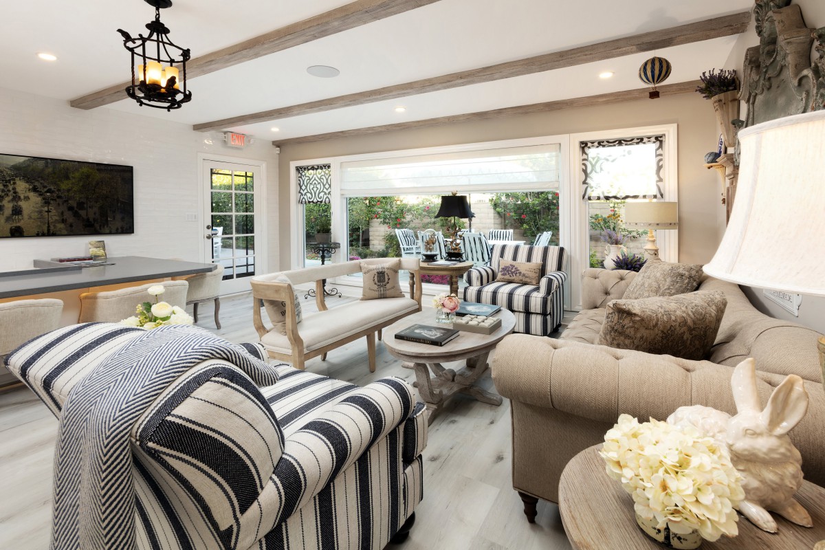 A cozy living room with striped furniture and modern decor, filled with natural light.
