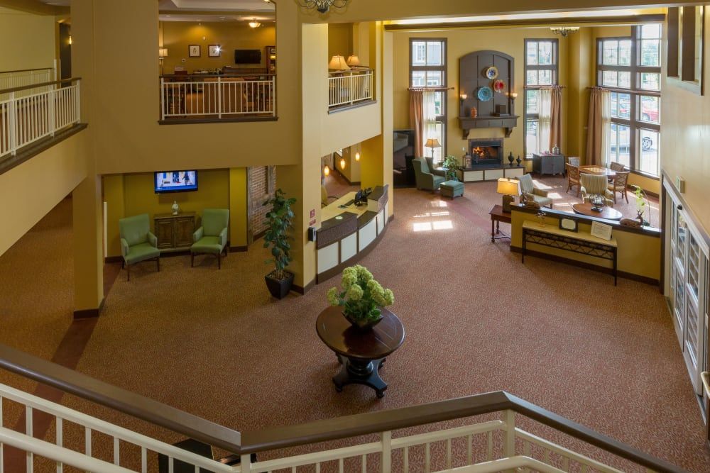 A spacious hotel lobby with a reception desk, seating area, and elegant decor.