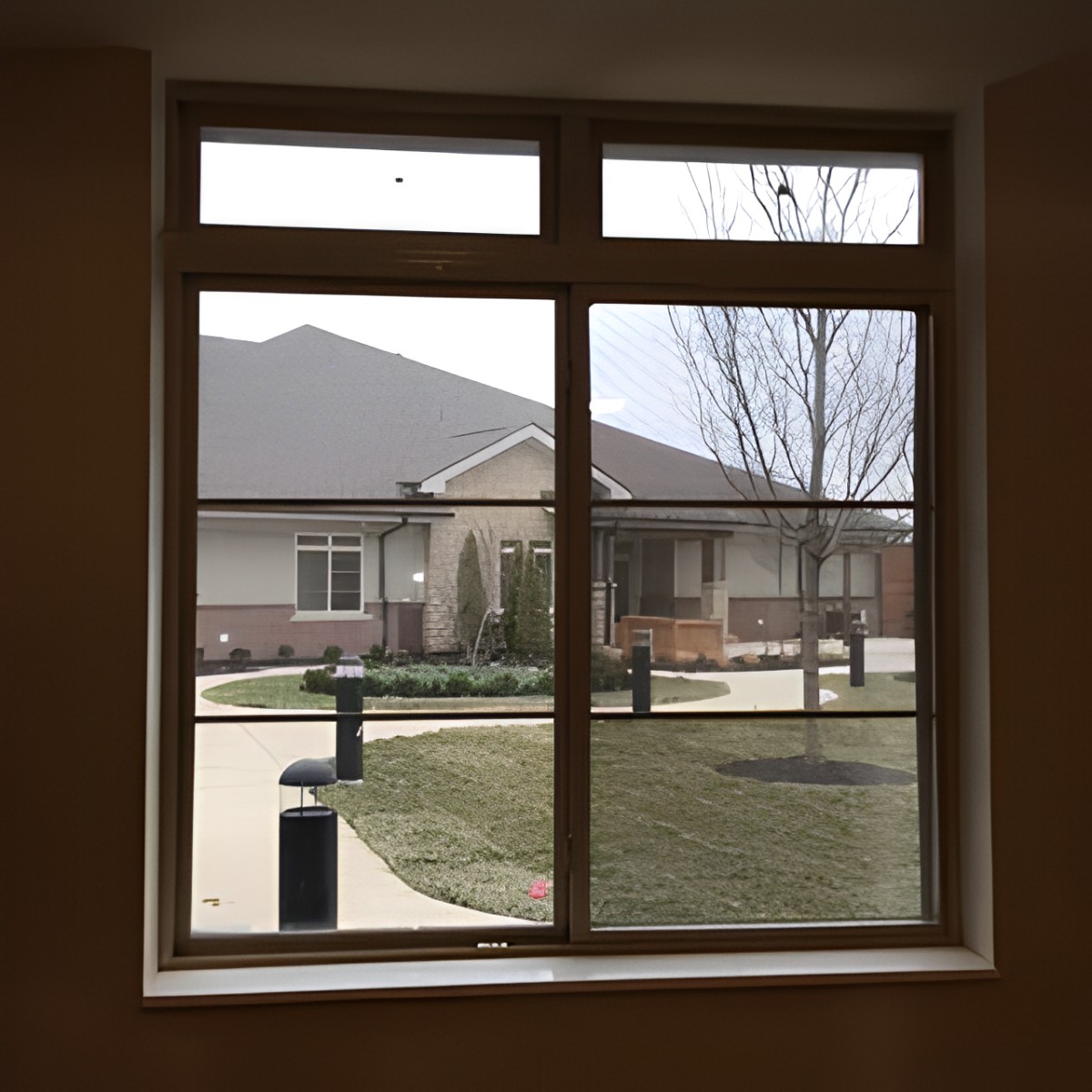 View of a house and yard through a window.