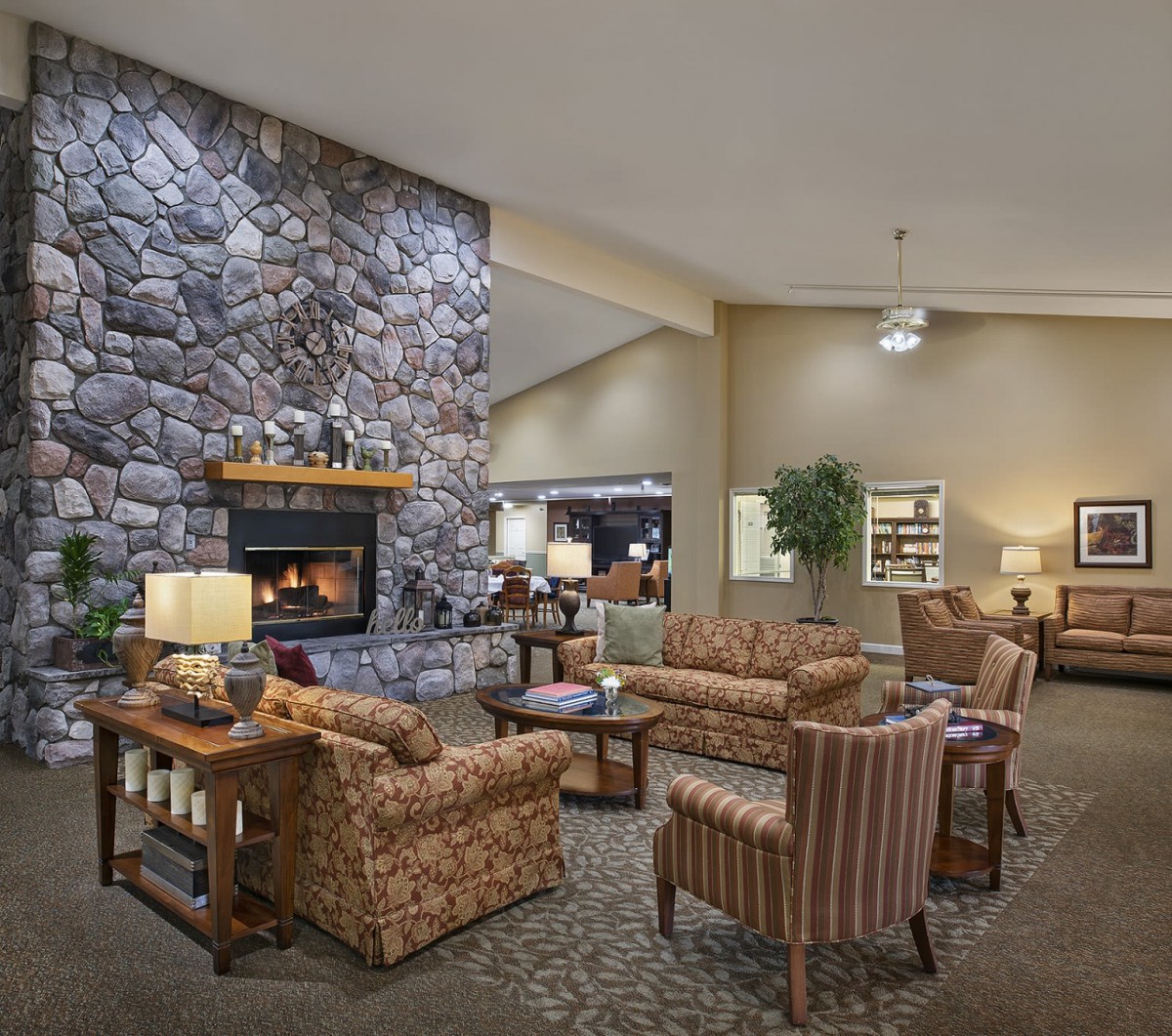 A cozy lobby with a stone fireplace, comfortable seating, and warm lighting.